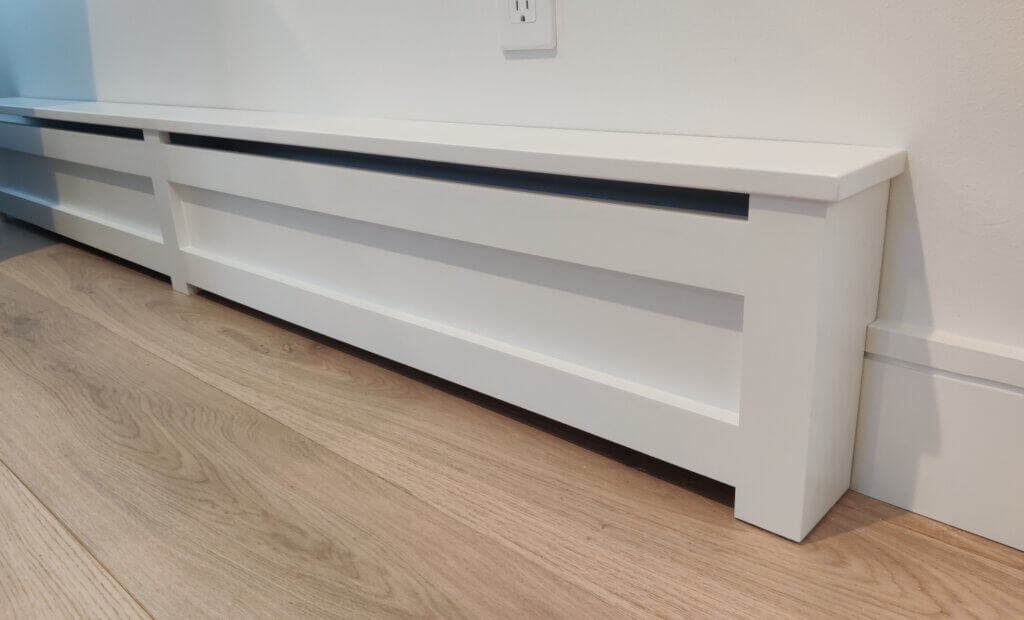 Modern shaker baseboard cover with solid panel installed on white wall